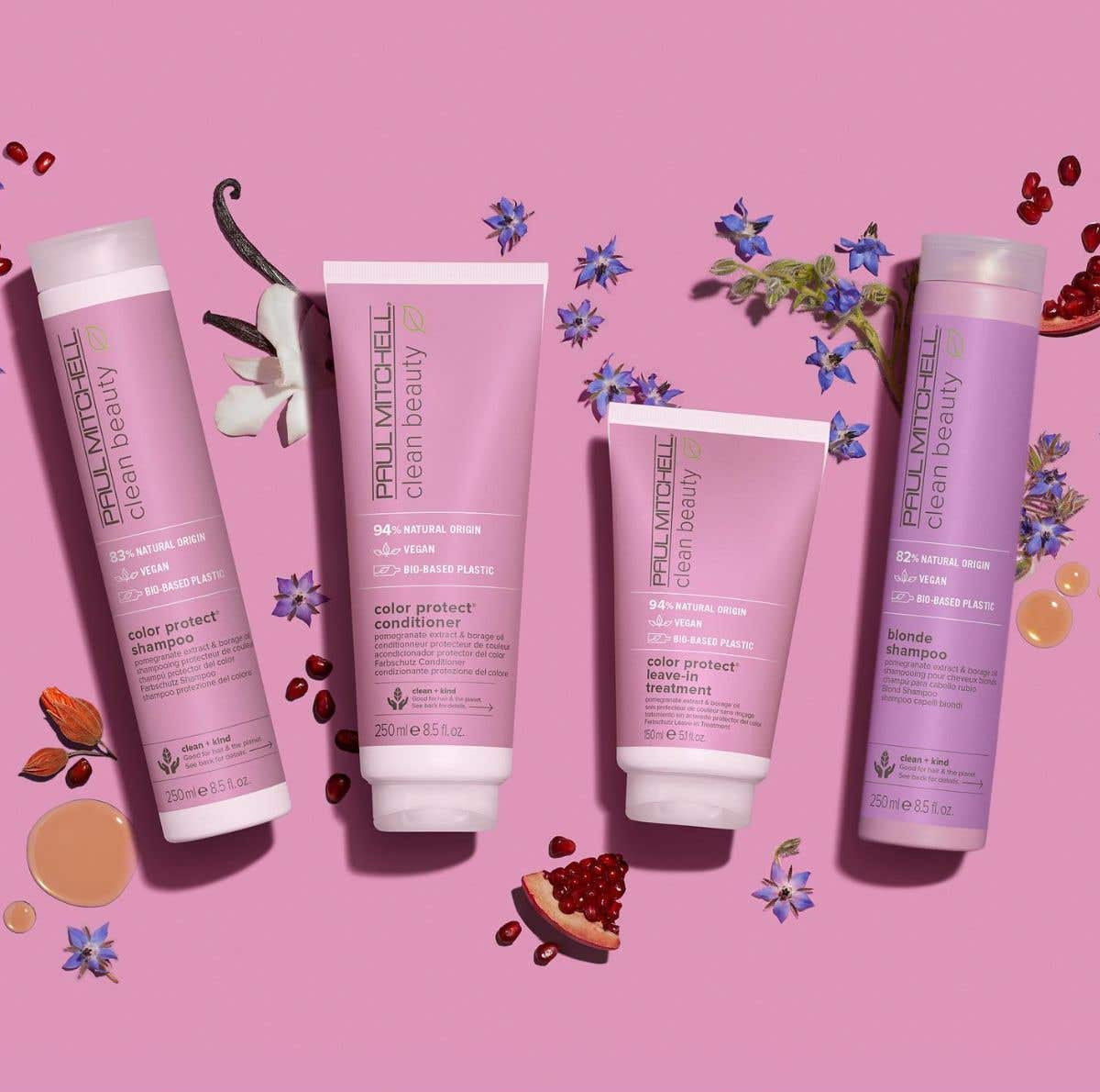 Clean Beauty Color Protect Collection artistic image with ingrendients around the bottles on a light pink & purple background