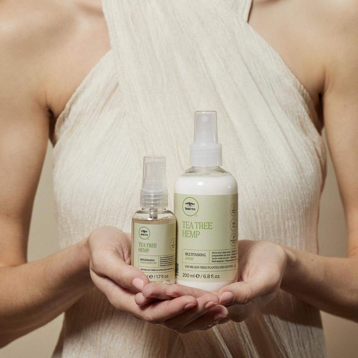 Tea Tree Hemp model holding Tea Tree Hemp Replenishing Oil + Multitasking Spray in front of chest