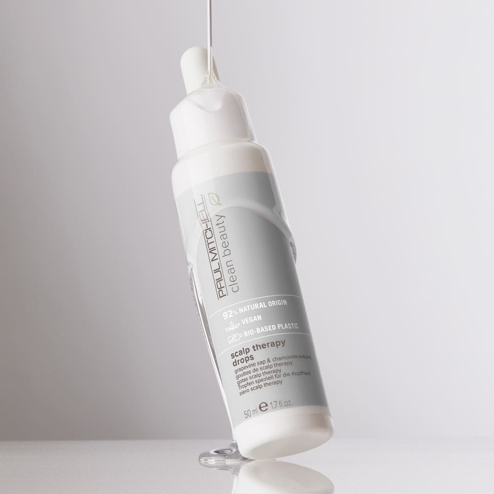 Artistic image of Clean Beauty Scalp Therapy Drop with serum dripping onto the bottle