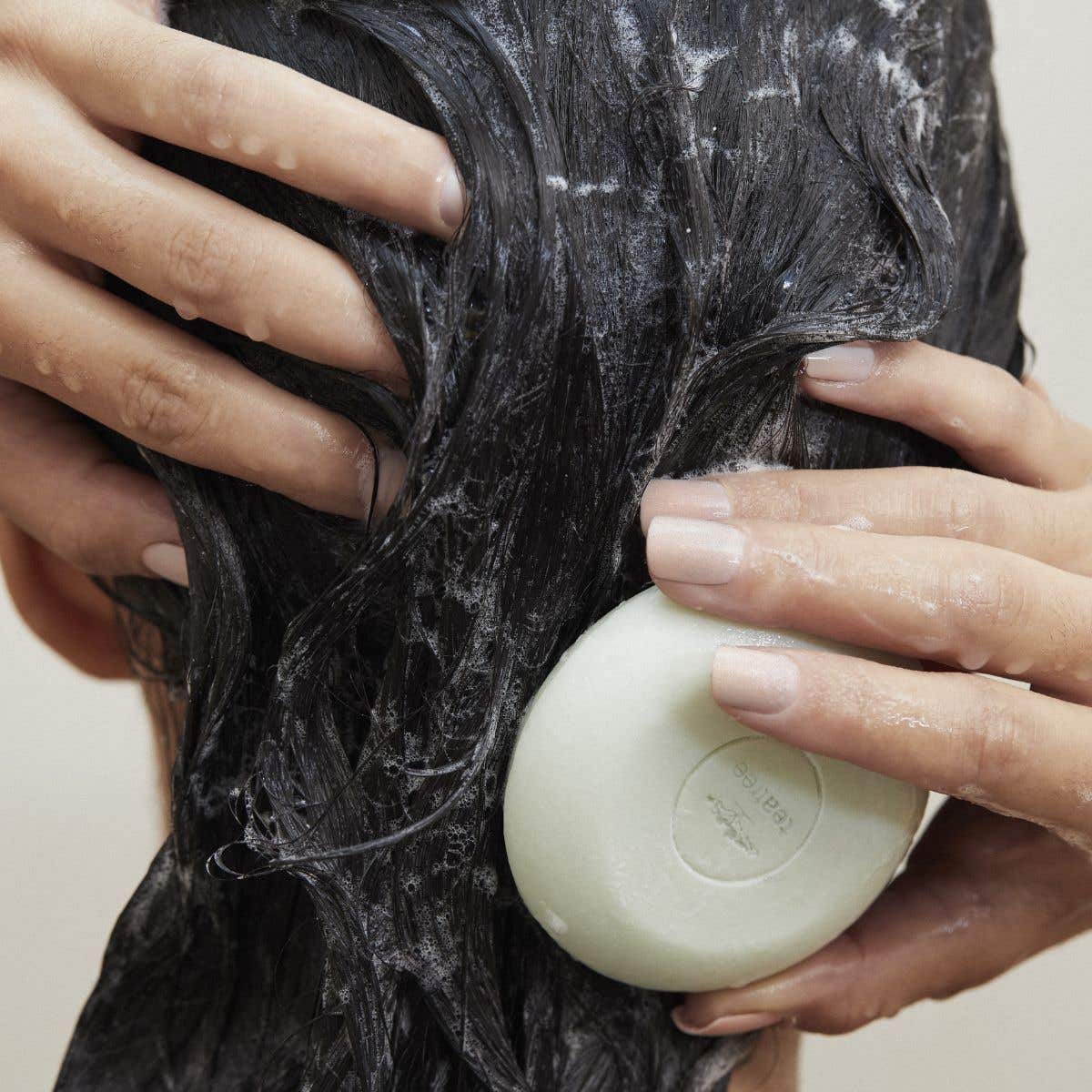 Tea Tree Special Shampoo Bar in use on female head with wet hair and suds dispersed