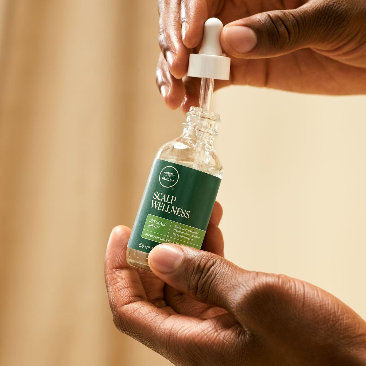 Tea Tree Scalp Wellness Dry Scalp Serum close up of model dispensing contents.