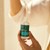 Tea Tree Scalp Wellness Scalp Defense Serum close up of model dispensing contents.