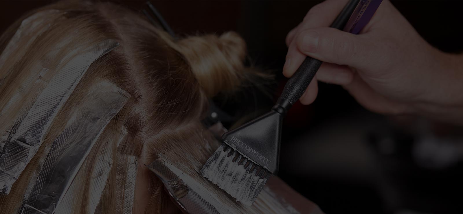 Image of stylist applying highlights to clients hair