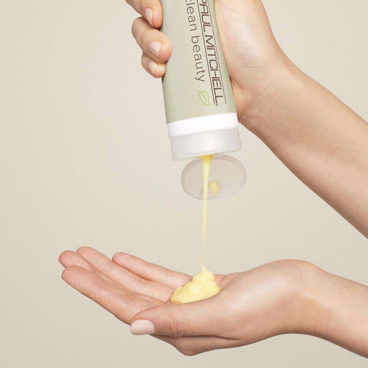 An image of someone dispensing Everyday Shampoo into their hands on a soft cream background