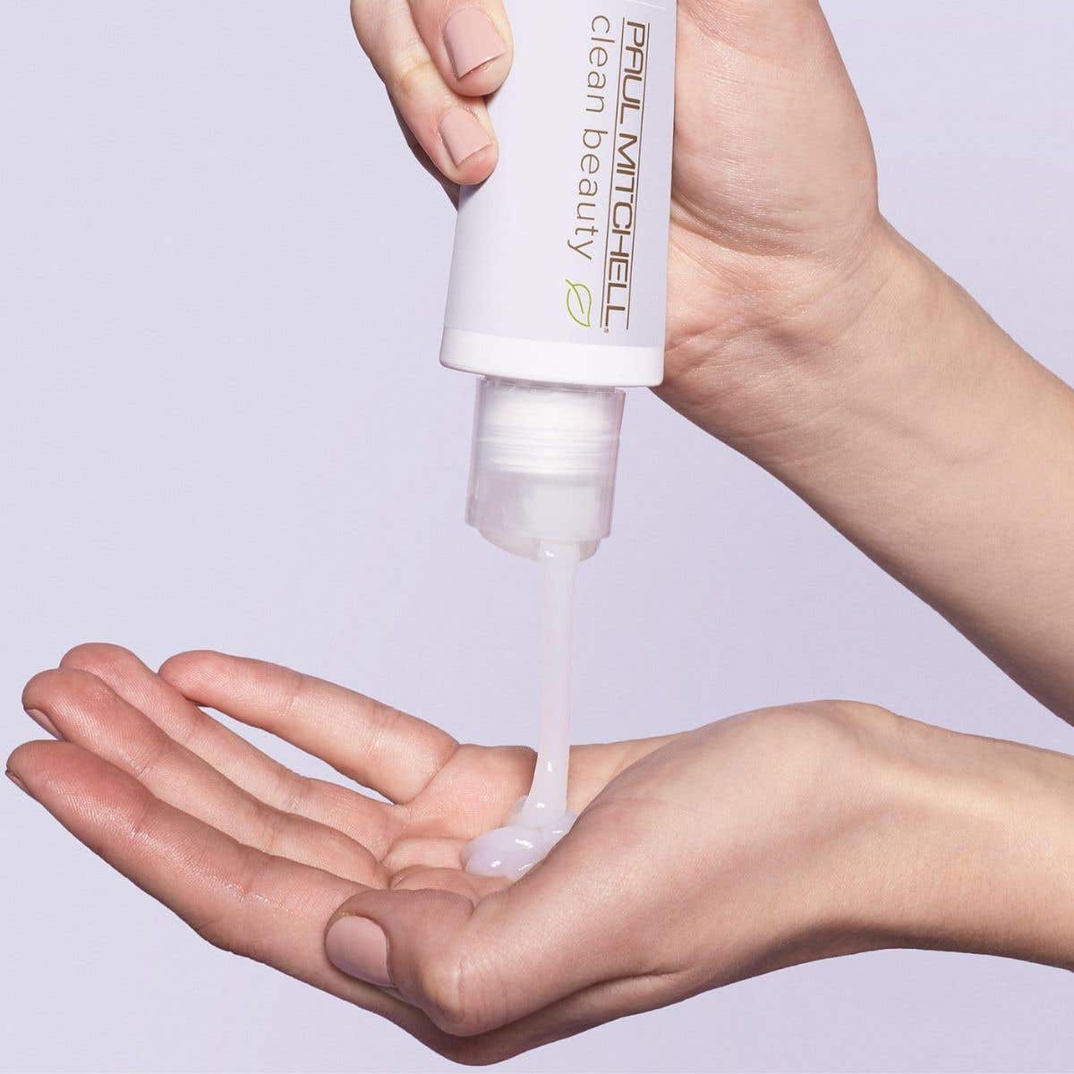 Image of someone dispensing the Leave-In treatment into their hands on a soft purple background