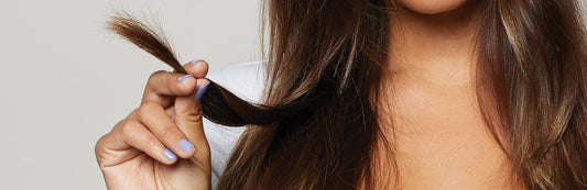image of a woman examining the ends of her brunette hair