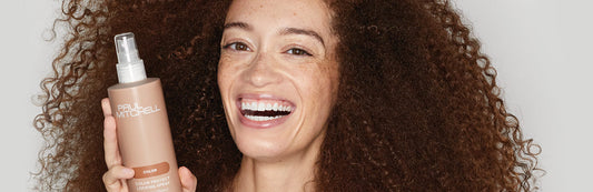 image of a woman holding a bottle of Color Protect Locking Spray