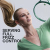 Model playing tennis with graphic text: Serving full frizz control.