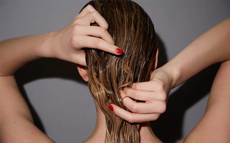 image of a model applying a hair treatment