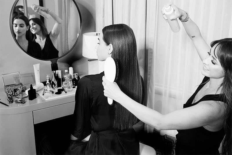 Step two, the stylist is spraying Neuro Smooth on model's hair