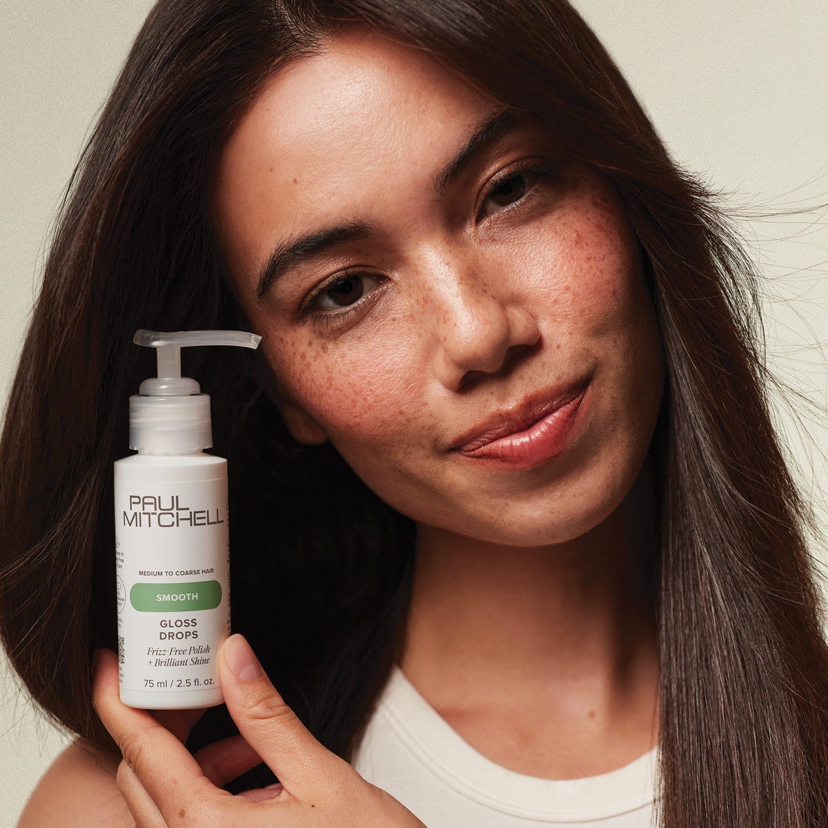 woman holding a bottle of Gloss Drops