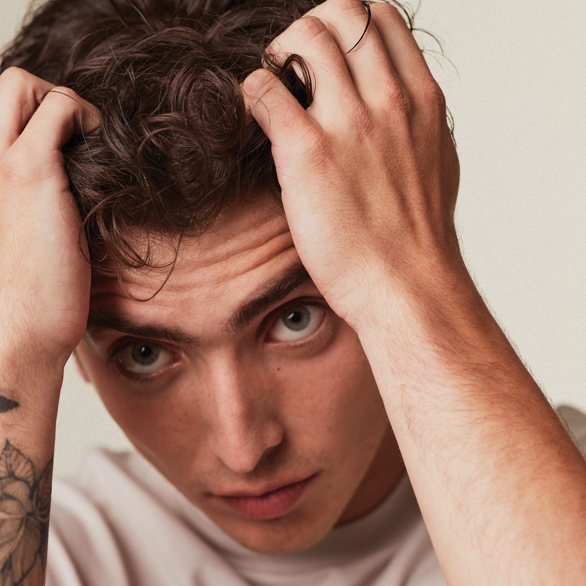 man applying hair styling product into his hair