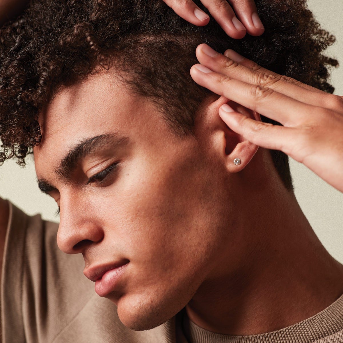 man applying hair styling product into his hair