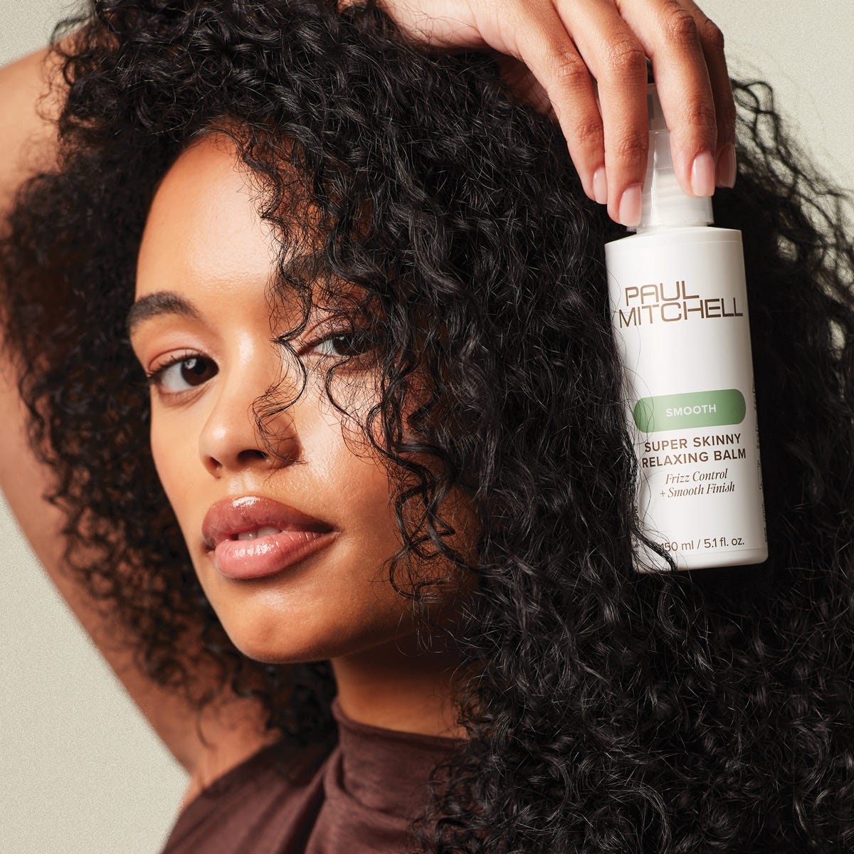 woman holding a bottle of Super Skinny Relaxing Balm
