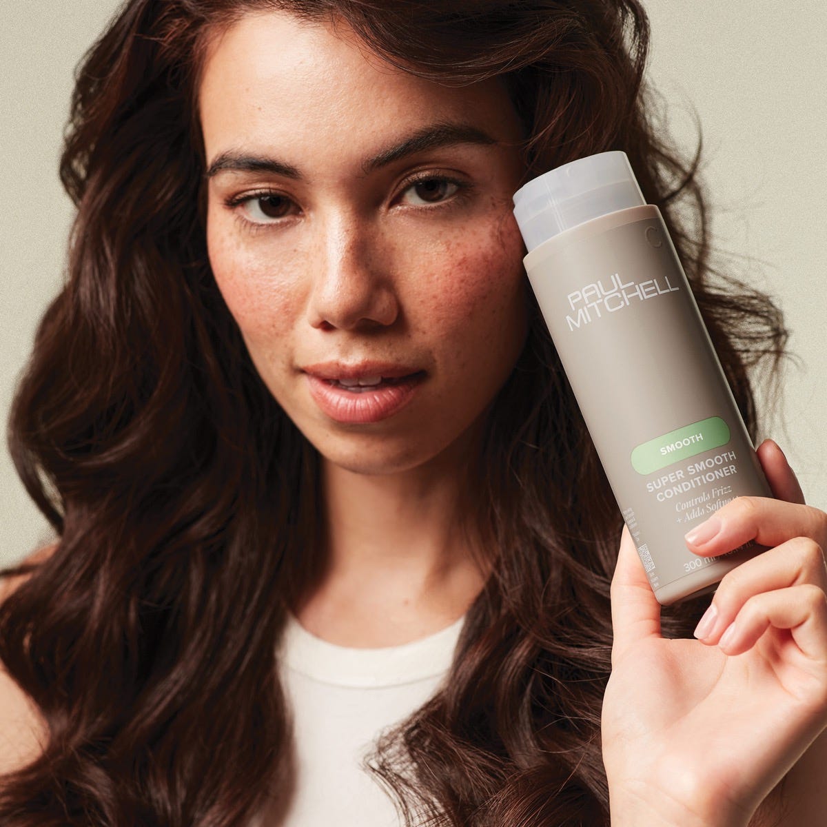 woman holding a bottle of Super Smooth Conditioner