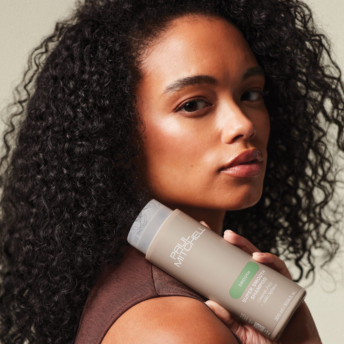woman holding a bottle of Super Smooth Shampoo