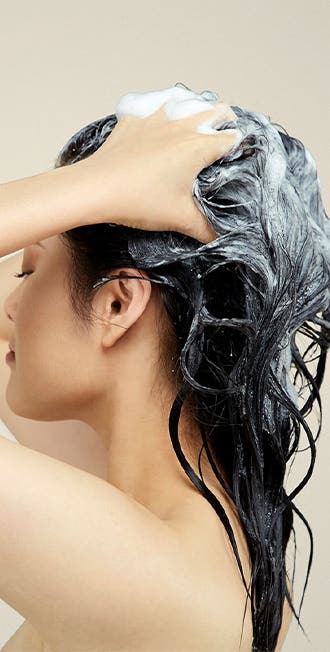 Image of model washing their hair in the shower