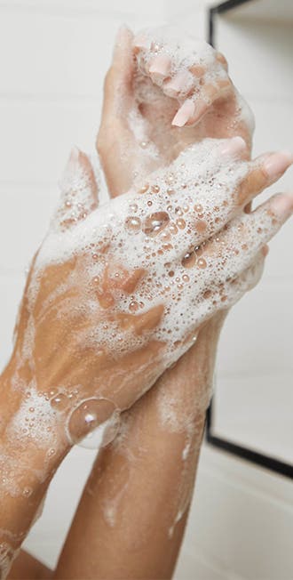 Image of sudsy, manicured hands in the shower