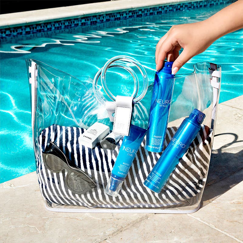 image of a sunny poolside view where we see a transparent tote bag filled with Neuro styling products